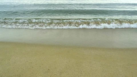 Close-up of a gentle sea wave rolling onto a sandy beach Vídeos de archivo 335040895