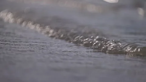 Close up of gentle wave break in slow motion on tropical island beach sun flare Stock Footage 288038576