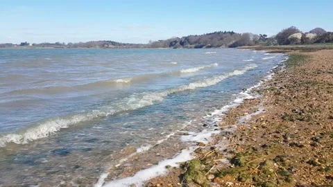 Close up of gentle waves on a sandy beach on a clear summers day Stock Footage 156256033