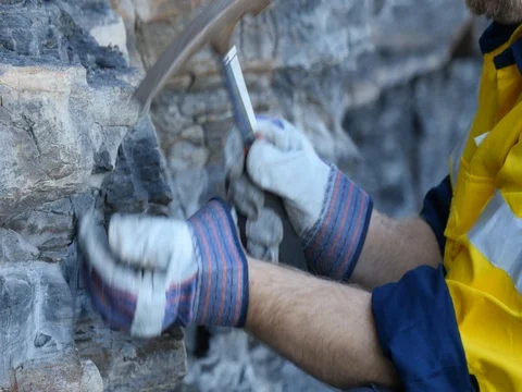 Close up of Geologist hand taking rock sample with pick axe mining exploration  Stock Footage 78592463