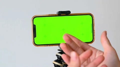 Close-up of gesticulating hands against green phone screen with motion tracking Video stock 223317946