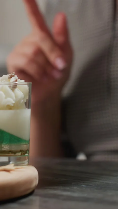 Close up of gesturing hand near handmade layered candles with shells in glass 스톡 동영상 344679096