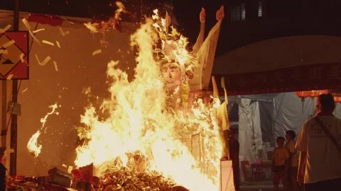 Close-Up of Giant Paper Effigy Consumed by Flames at Night during Hungry Ghost Stock Footage 345995192