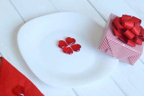 Close up.gift box and red hearts on a white plate. Stock Photos