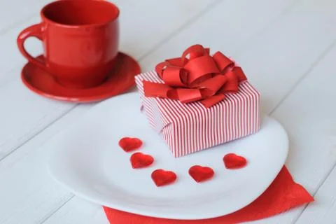 Close up.gift box and red Cup on the holiday table. Stock Photos