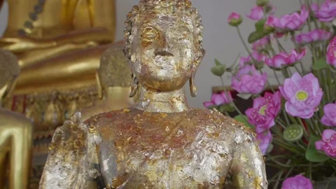 A close-up of a gilded Buddha statue covered in gold leaf, symbolizing devotion Stock-Footage 303399056