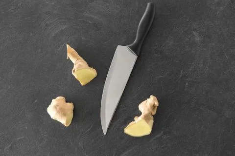 Close up of ginger root and knife on stone table Stock Photos