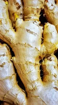Close up ginger root surface showing natural organic spice texture background Stock Photos