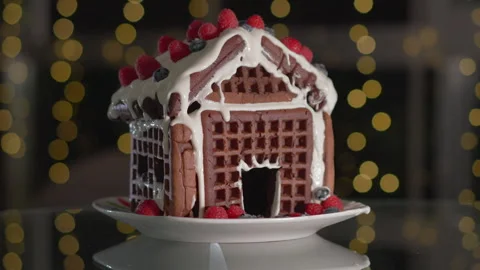 Close-up of a gingerbread house decorated with fresh berries, set against a Stock Footage 317321922