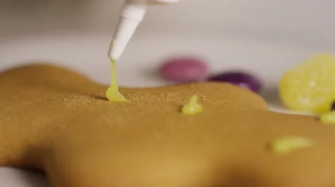 Close up of a gingerbread man being decorated with icing, in slow motion Video stock 57310080