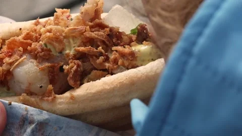 Close-up. The girl eats a hot dog generously smeared with mustard Street food Stock Footage 287899259