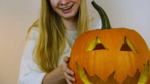 Close-up. The girl picks up a pumpkin. The camera follows the pumpkin. Stock Footage 219260623