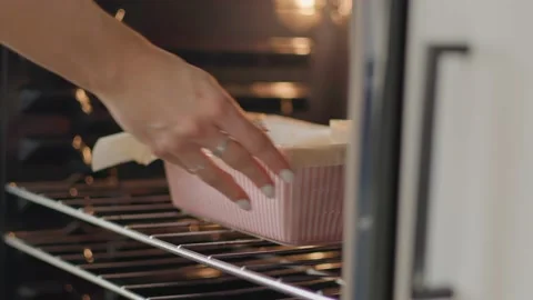 Close up, girl placing fall baking recipe in oven 库存影片 219405425