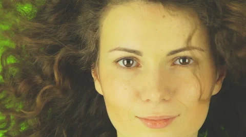 Close  up of a girl' s face, the wind blowing in her hair, a green background Video stock 42476344