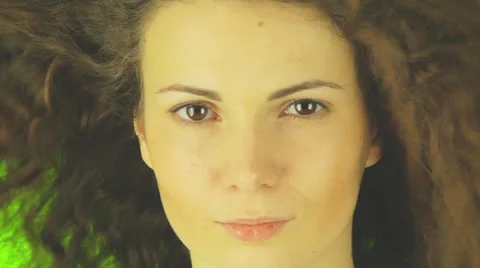 Close  up of a girl' s face, the wind blowing in her hair, a green background Video stock 42476372