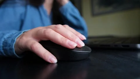 Close-up of girl using computer mouse with laptop on desk, simple everyday home Stock Footage 320422008