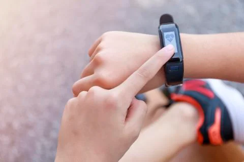 Close up Girl using smartwatch touching button and touchscreen on active spor Stock Photos