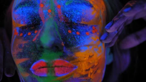 Close-up of a girl's face with an UV pattern in the light of a fluorescent lamp. Stock Footage 265861133