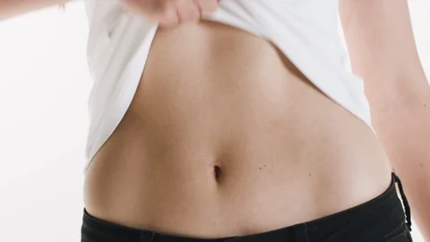 Close up view of stomach. Beautiful woman with slim body in