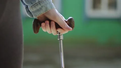 Close-up of a girl's hand leaning on a cane. foot problem, cane in girls Stock Footage 235471353