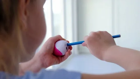 Close-up of a girl's hand sharpens a blue pencil. Stock Footage 150508128