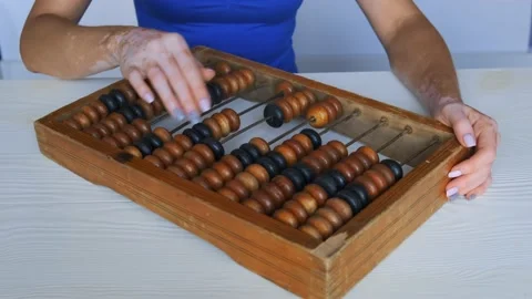 Close-up of a girl's hands counting on old wooden abacus. Vitiligo disease Stock Footage 165494132
