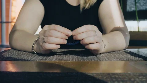Close-up of the girl's hands at the table in the cafe Stock Footage 108944059