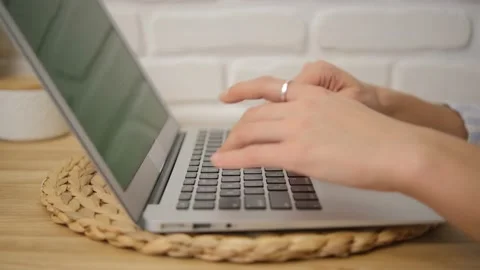Close-up of the girl's hands typing text. Side view. Green laptop screen. Select Stock Footage 148472936