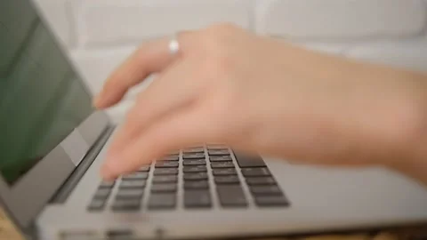 Close-up of the girl's hands typing text. Side view. Green laptop screen. Select Stock Footage 149231899