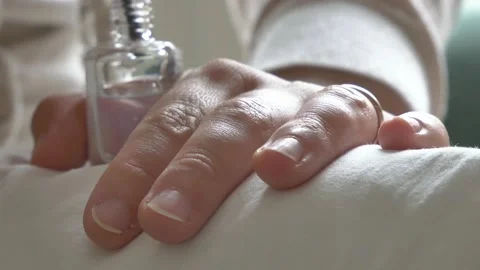 A close-up of a girl's hands while she is putting on her nail polish. Stock Footage 130905448