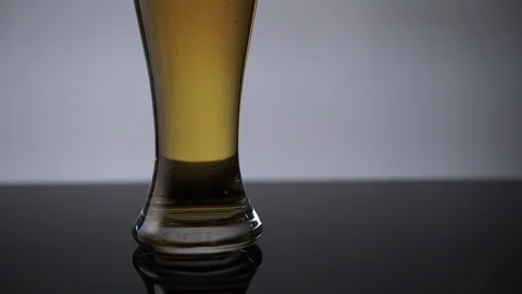 Close-up of glass of beer with rising bubbles, bottom-upwards shot Stock Footage 113337962