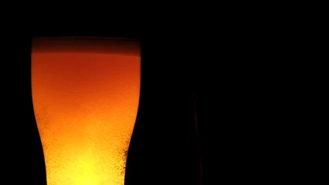 Close-up glass of beer with structure whirlpool and rising up air bubbles around Stock Footage 103547606
