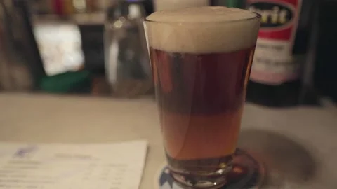 A close up of a glass of beer on a table Stock Footage 155452194