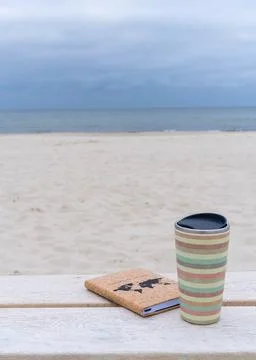 Close up of a glass of coffee with a notepad on a light bench against  back.. Foto stock