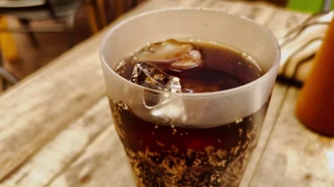 Close Up of Glass Filled With Ice Cold Cola Soft Drink on Wooden Table Video stock 342235843