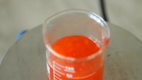 Close-up of a glass flask in which a red substance is mixed. Video stock 127320909
