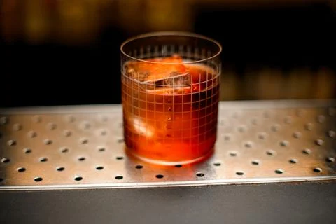 Close-up of glass with grid pattern full of cold cocktail on bar counter Stock Photos