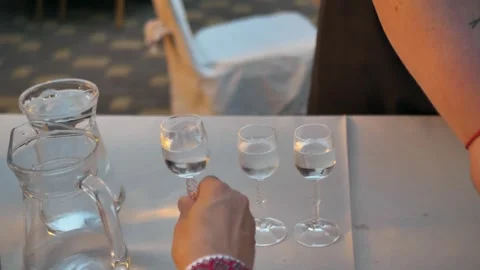 Close-up of glass in hand filled with alcoholic drink. gin tasting Stock Footage 283550176