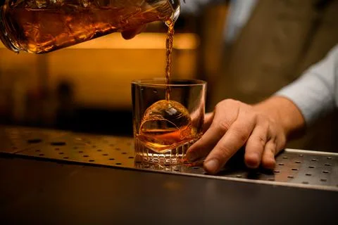 Close-up of glass with piece of ice into which beverage is poured Photos