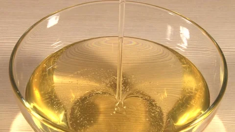 Close up of glass plate standing on table with pouring honey shooted from above 動画素材 220651727