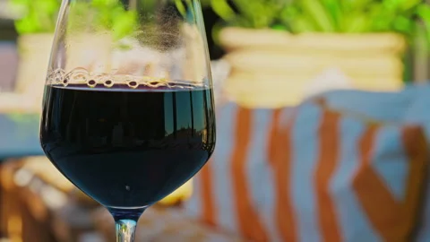 Close up of a glass of red wine on a table at a terrace Stock Footage 305949833