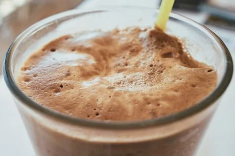 Close-up of a glass of refreshing cold iced coffee with thick foam and yell.. Stock Photos