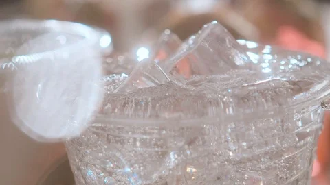 Close-up glass of refreshing sparkling water and ice cubes. Splashing water Stock Footage 113799352