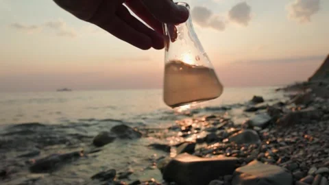 Close up of glass test sample flask of dirty water examines by ecologist Stock Footage 255283268