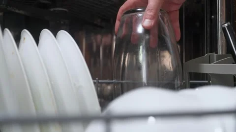 Close-up of a glass vase being placed in a silver dishwasher with dirty dishes Vídeos de archivo 313908027