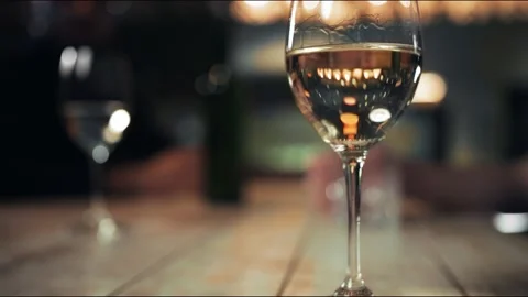 Close-up: a Glass of white wine is on the table. Warm cozy atmosphere Stock Footage 140710987