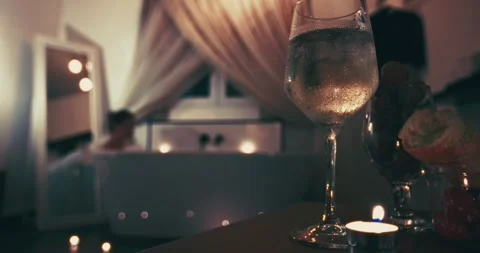 Close-up of a glass of wine on a table in a romantic bathroom. Stock Footage 295373840