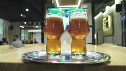 Close-up of glasses with beer in front of a TV with a live broadcast Stockbeeldmateriaal 272212859