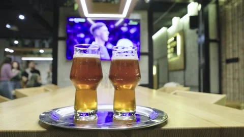 Close-up of glasses with beer in front of a TV with a live broadcast Stock Footage 272221185