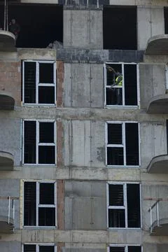 Close up of glazier installing white window frames into unfinished apartments Stock Photos